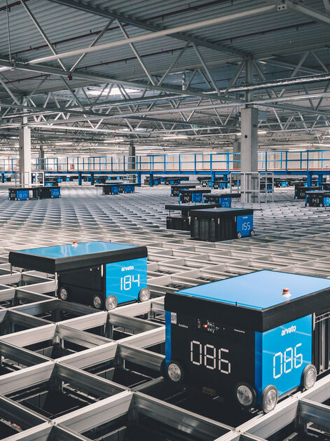 A logistics AutoStore grid with moving robots in an arvato warehouse